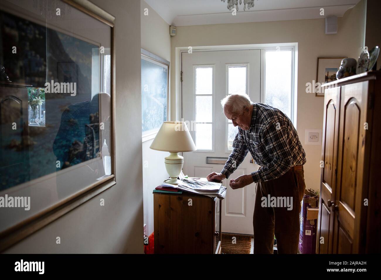87 Jahre alte ältere Menschen, die allein leben, in seinem Flur, England, Vereinigtes Königreich Stockfoto