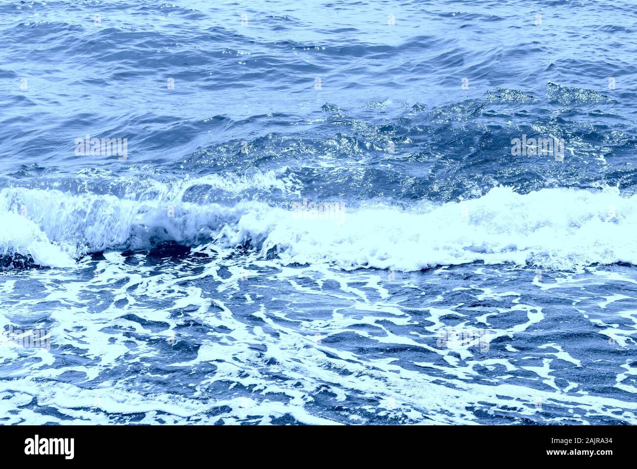 Meer oder Ozean Wasser mit wenig entspannte Wellen und Reflexion. Schönen Farbverlauf mit beige und blau Farben. Farben im klassischen Blau Stockfoto