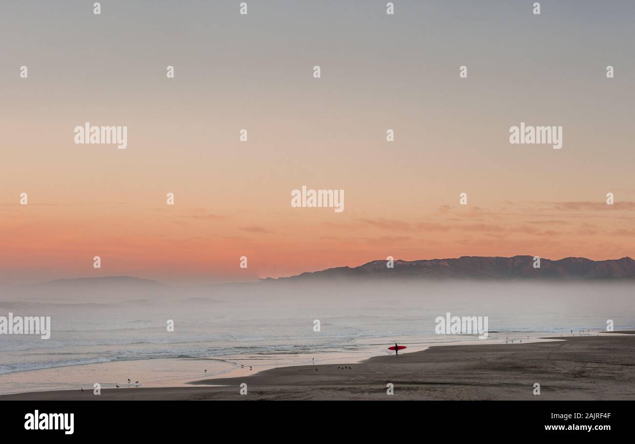 Lone Surfer prüft Surfen bei Sonnenaufgang in Kalifornien Stockfoto