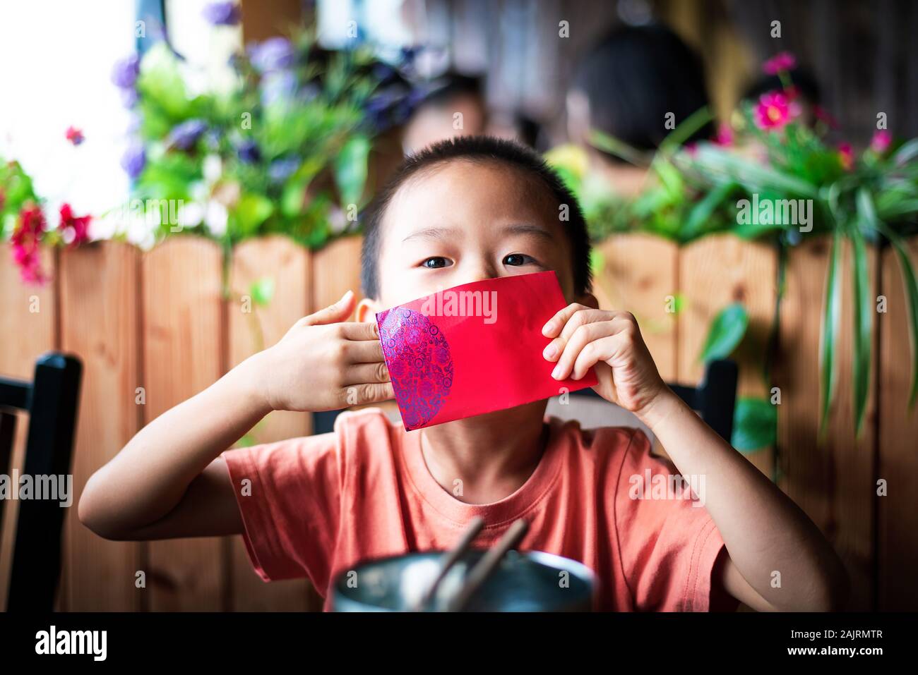 Chinesischer junge Die rote Tasche auf dem Esstisch Stockfoto