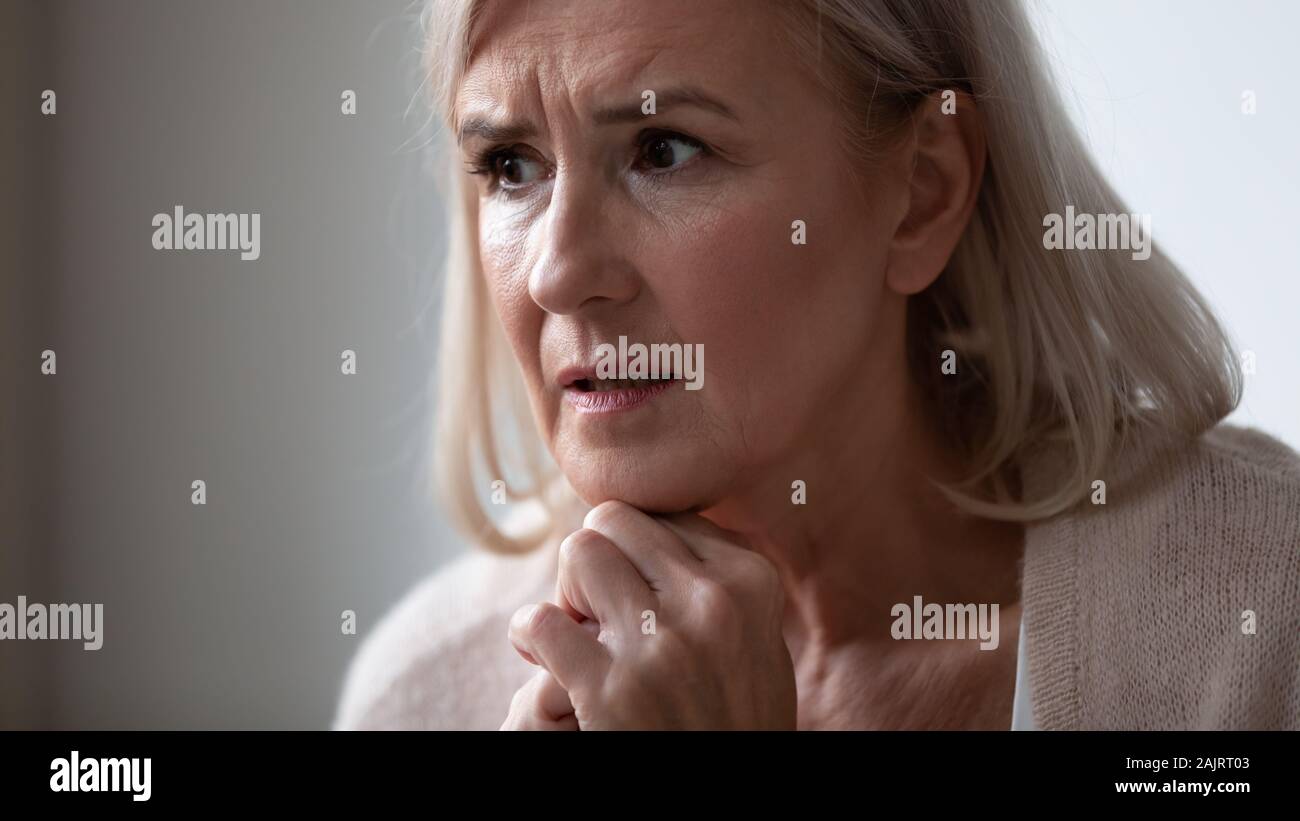 Nahaufnahme von traurige ältere Frau, die sich in der Entfernung denken Stockfoto