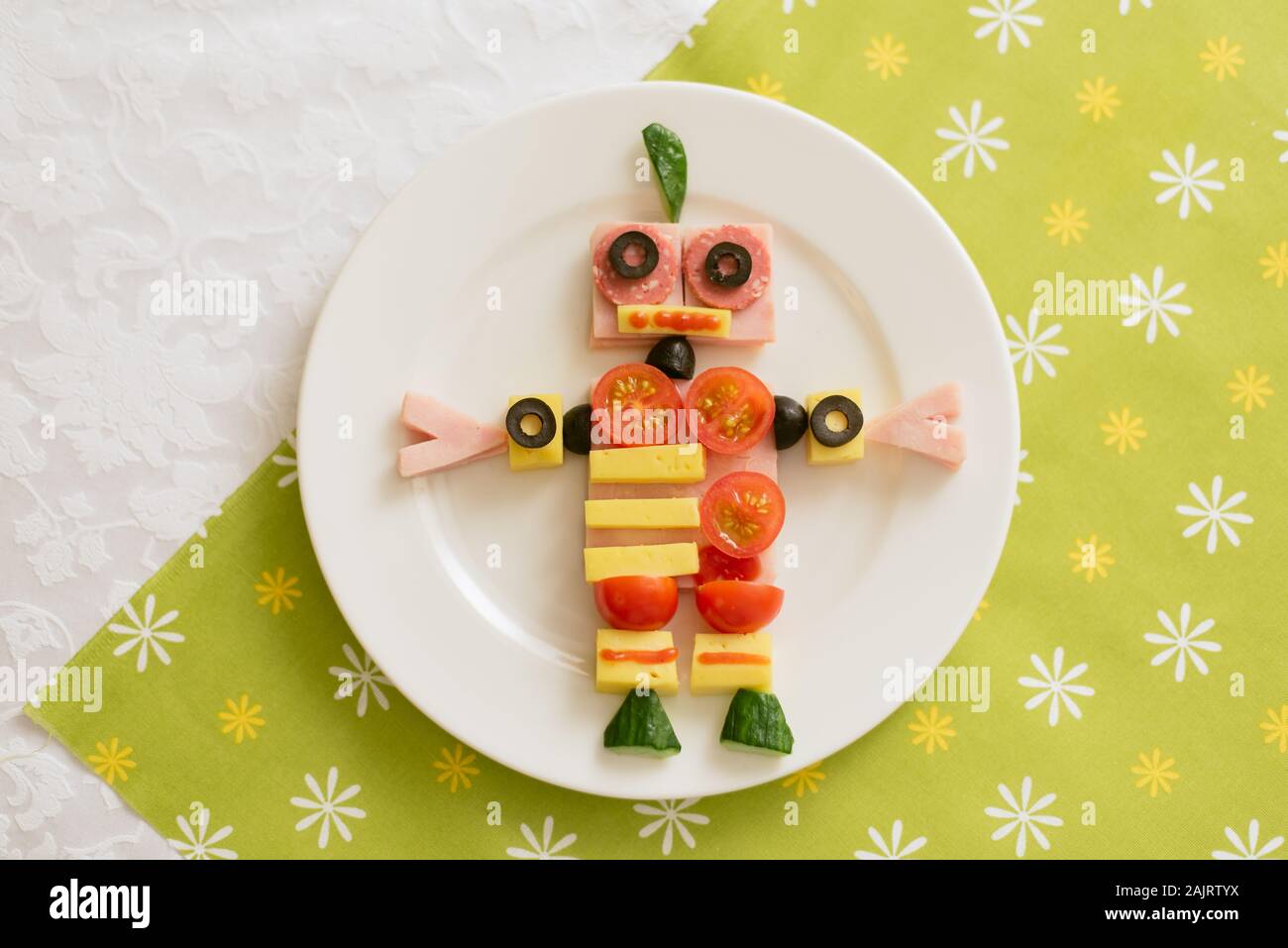 Nahrung in Form eines Roboters. Babynahrung auf grünem Hintergrund Stockfoto