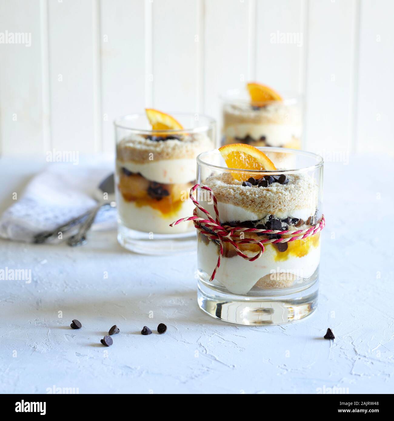 Konzept der italienisches Essen. Orange Tiramisu, italienische Dessert von finger Keks- und Mascarpone in einem Glas auf weißem Hintergrund. Stockfoto