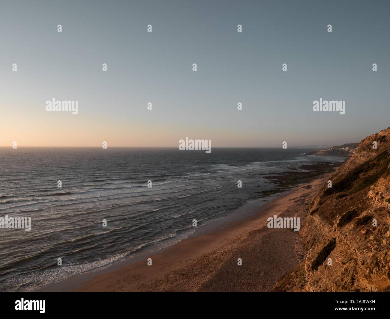 Wellen am Strand bei Sonnenuntergang Stockfoto