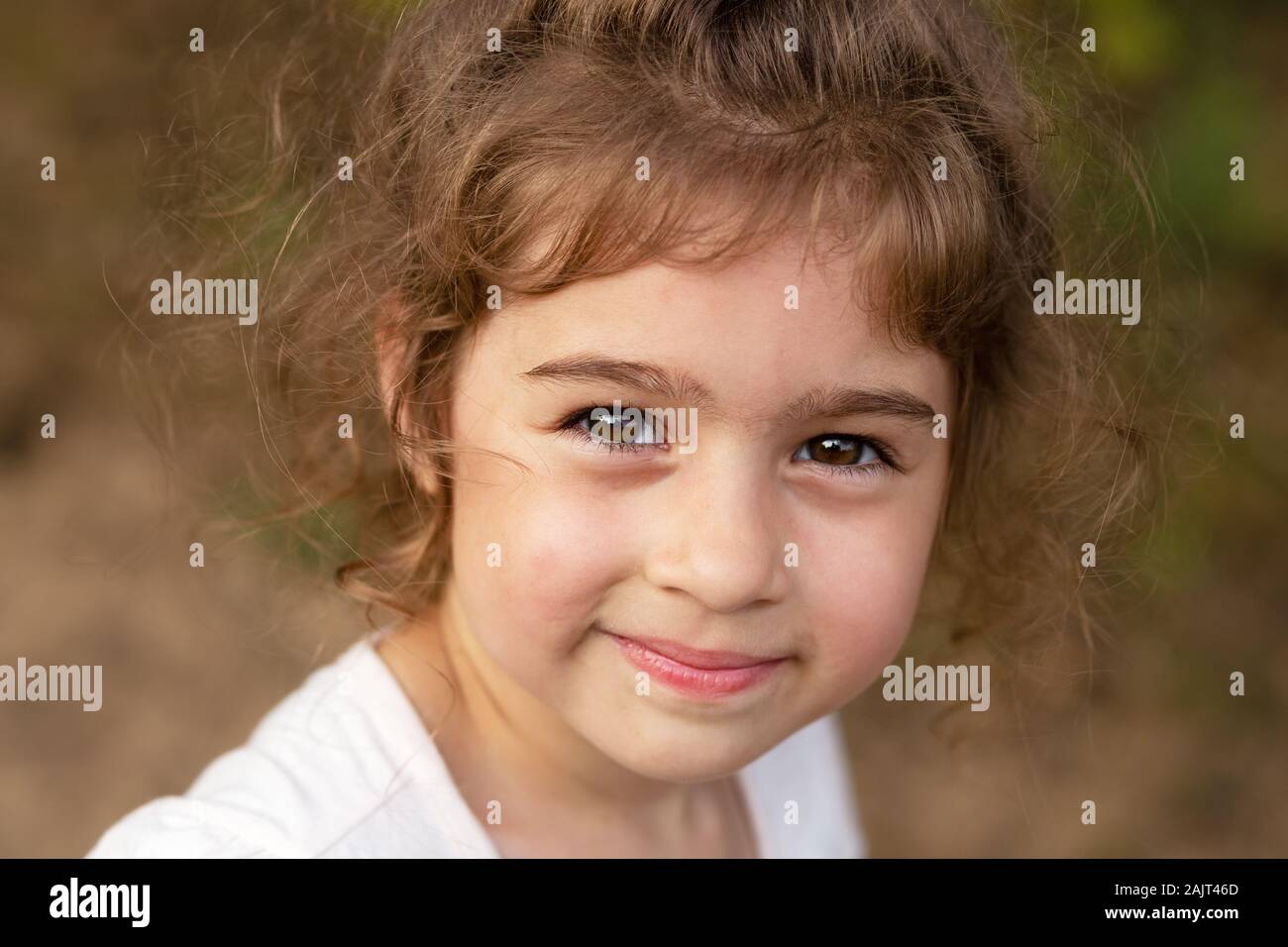 Portrait von lächelnden schönen kleinen Mädchen am Grün des Sommers Park. niedliche Kind in die Kamera schaut Stockfoto