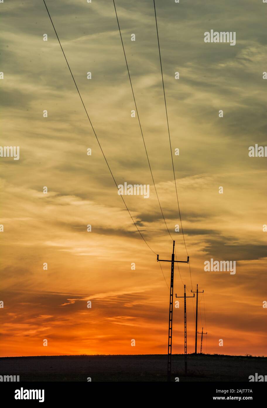 Bunte Wolken nach dem Sonnenuntergang und elektrischen Polen Stockfoto
