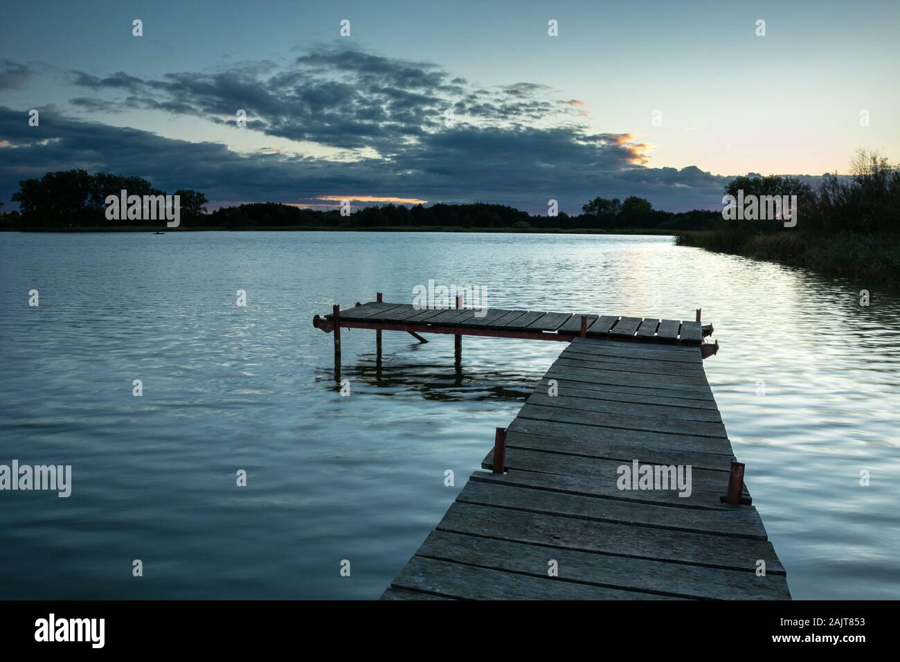 Steg auf einem ruhigen See und dunkle Wolken, Abendlicher Blick Stockfoto