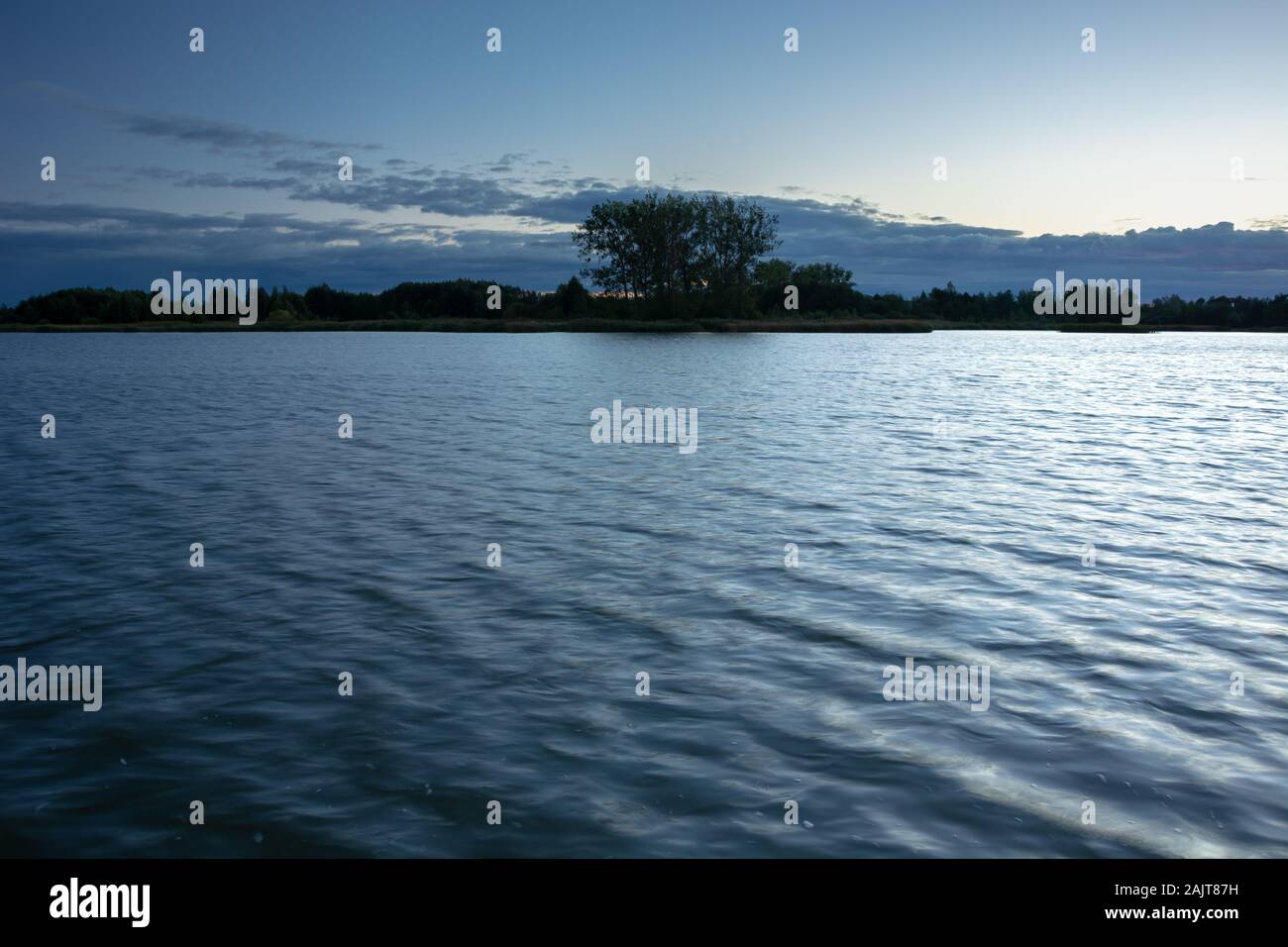Bäume am Ufer eines ruhigen See und am abend wolken Stockfoto