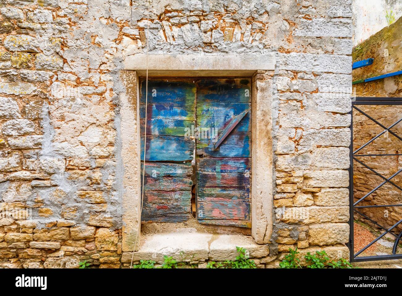 Wooden Türen in eine Tür in eine Mauer aus Stein, die in der historischen Altstadt in Ballen, einer kleinen Stadt auf dem Mont Perin in der Gespanschaft Istrien, Kroatien Stockfoto