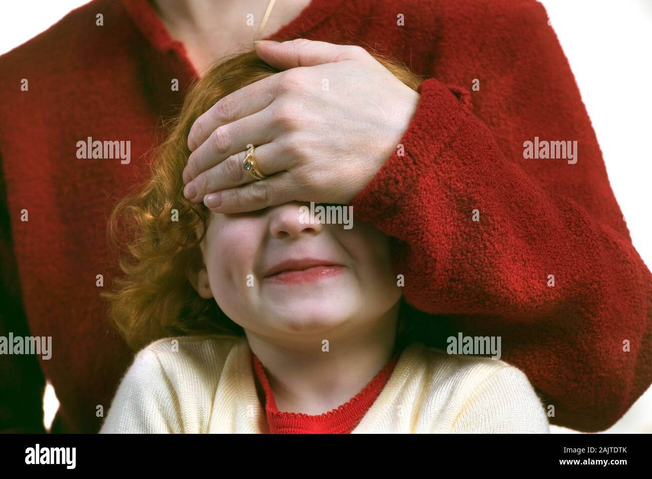 Kleine rothaarige Mädchen mit der Mutter mit der Hand über die Augen Stockfoto