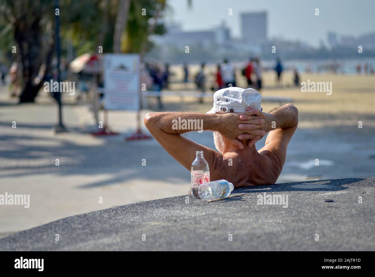 Man entspannen mit Hände hinter den Kopf und im Blick auf Pattaya Beach Road, Thailand Südostasien Stockfoto