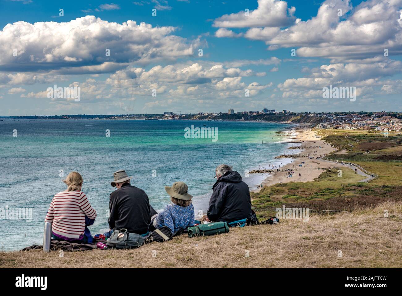 CHRISTCHURCH, Großbritannien - 01 September: Menschen sitzen auf einer Klippe mit Blick auf das Meer im Sommer in Hengistbury Head am 01 September, 2 Stockfoto