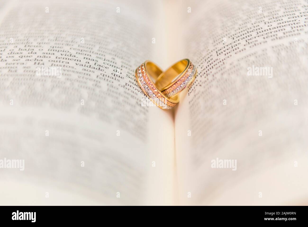 Hochzeit Ringe auf einem offenen Bibel" Bíblia Sagrada". Konzept der Union, Liebe, Freundschaft, Treue. Religiöse union. Selektive konzentrieren. Stockfoto