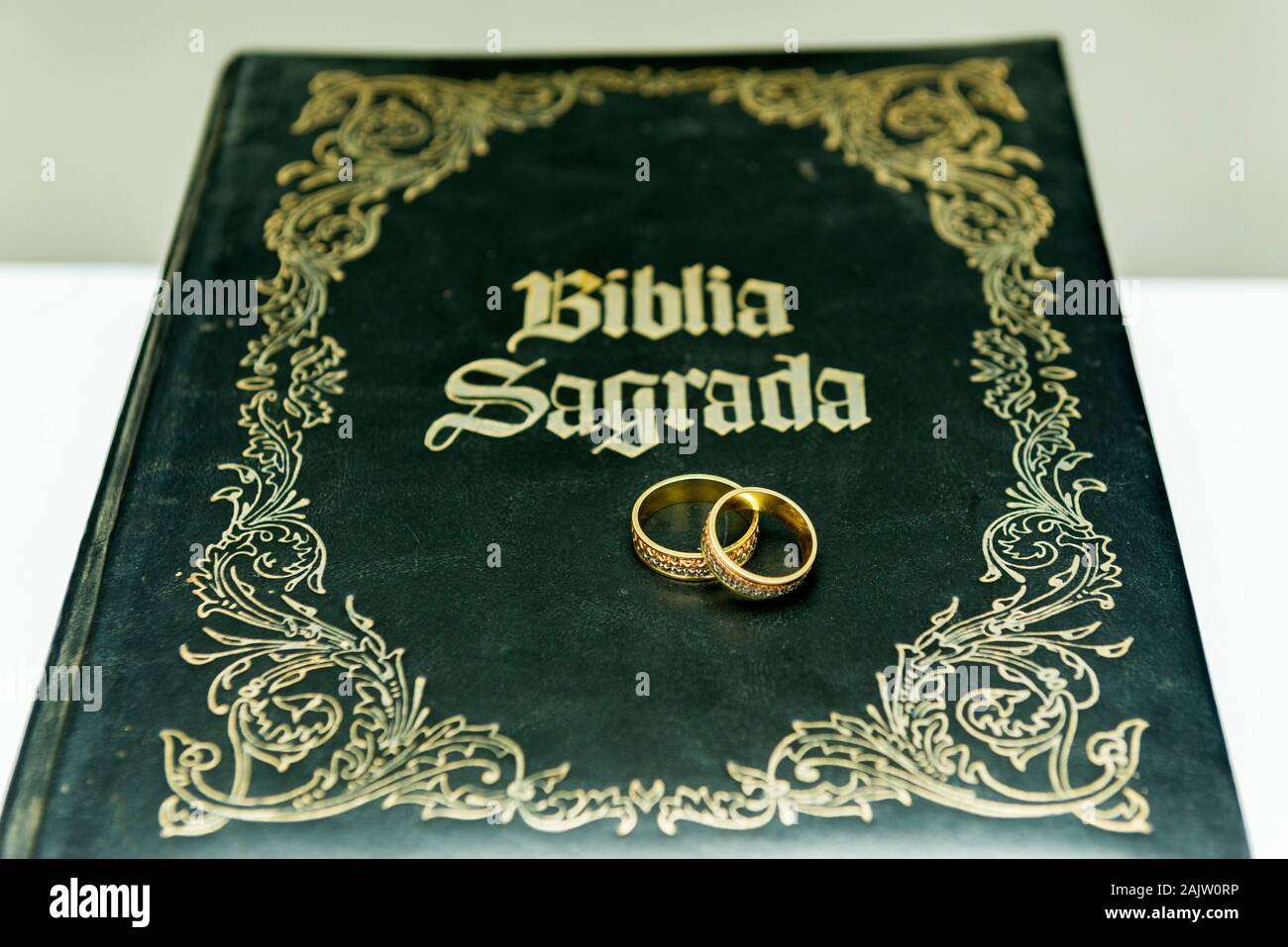 Hochzeit Ringe auf einem heiligen Bibel' Bíblia Sagrada". Konzept der Union, Liebe, Freundschaft, Treue. Religiöse union. Selektive konzentrieren. Stockfoto
