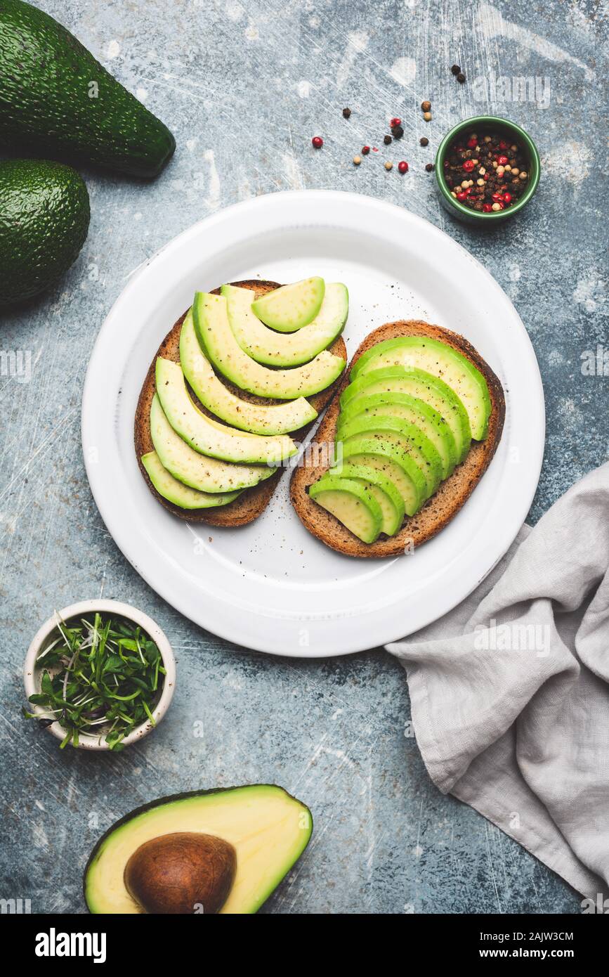Vegan avocado und Roggen Brot Toast auf Platte, Ansicht von oben. Gesunde Ernährung Stockfoto