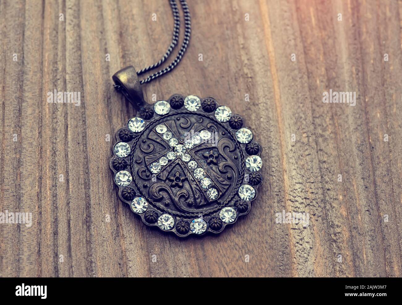 Kreuz-Anhänger auf Holz Hintergrund Stockfoto