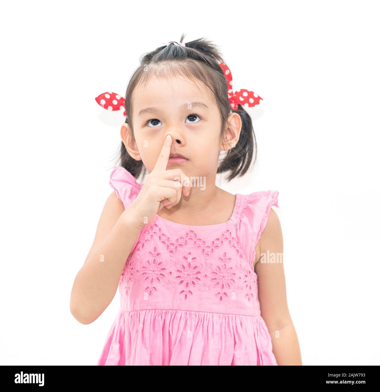 Kleine asiatische junge Mädchen mit Pokes einen Finger in der Nase Stockfoto