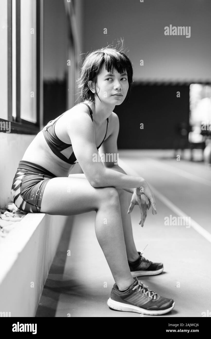 Junge schöne asiatische Frau, die an der Turnhalle arbeiten Stockfoto