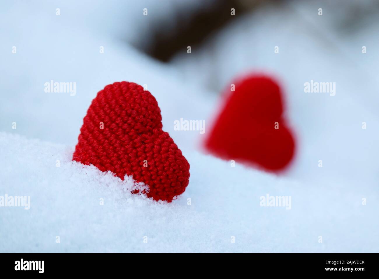 Valentinstag Herz, Grußkarte, zwei Rote gestrickt, Symbole der Liebe im Schnee. Hintergrund für romantische Veranstaltung, Feier oder Winter Wetter Stockfoto