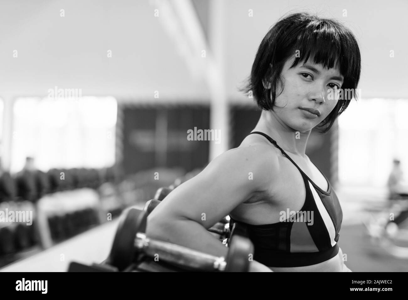 Junge schöne asiatische Frau, die an der Turnhalle arbeiten Stockfoto