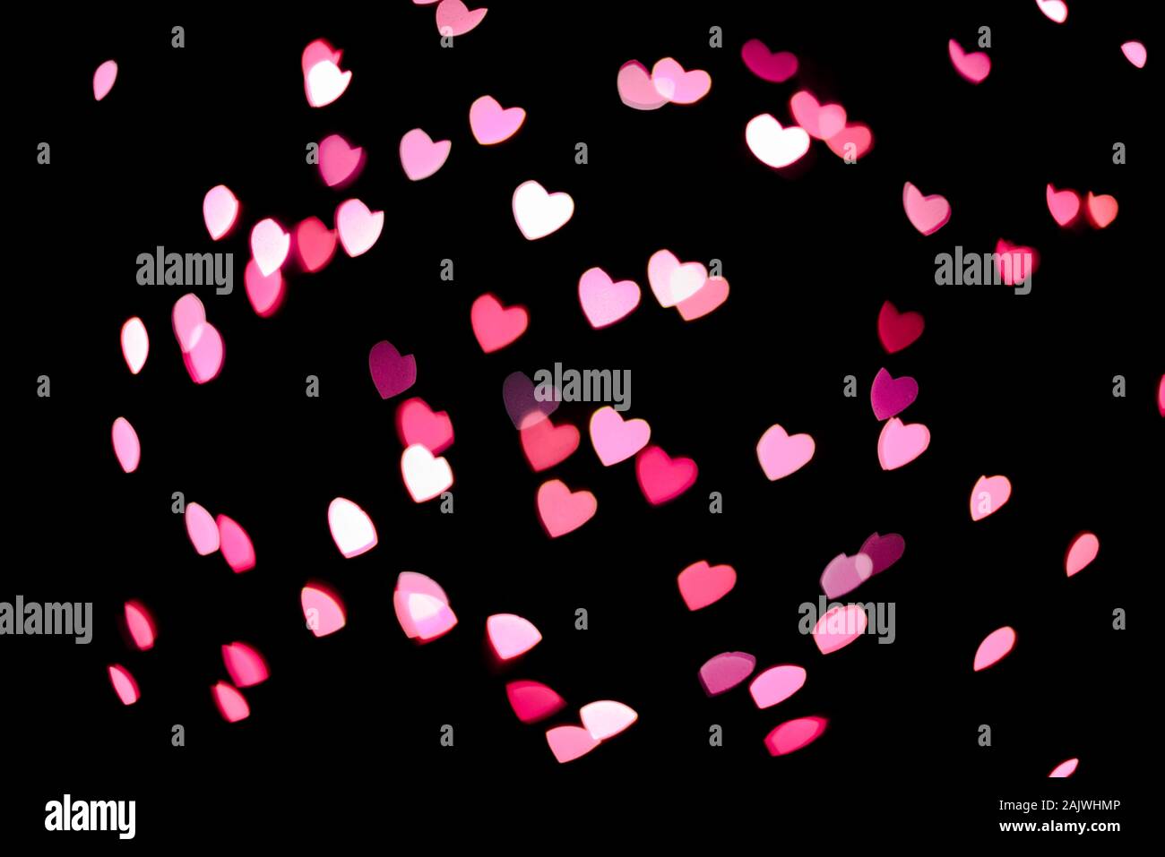 Viel rosa Herzen fliegen auf schwarzem Hintergrund Stockfoto
