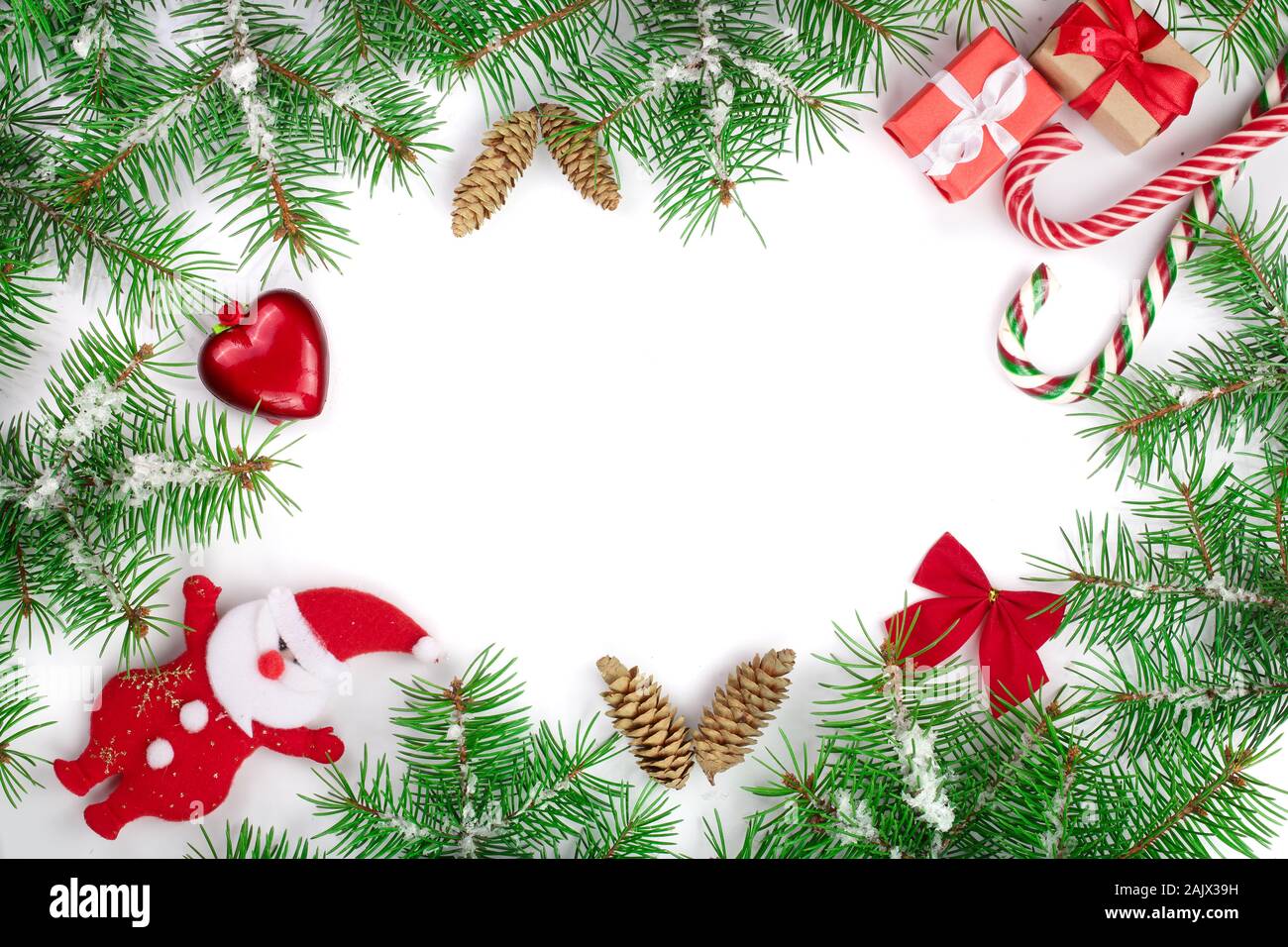 Weihnachten Rahmen der Fir Tree Branch mit Zuckerstangen und Schnee auf weißem Hintergrund mit Kopie Platz für Ihren Text isoliert Stockfoto