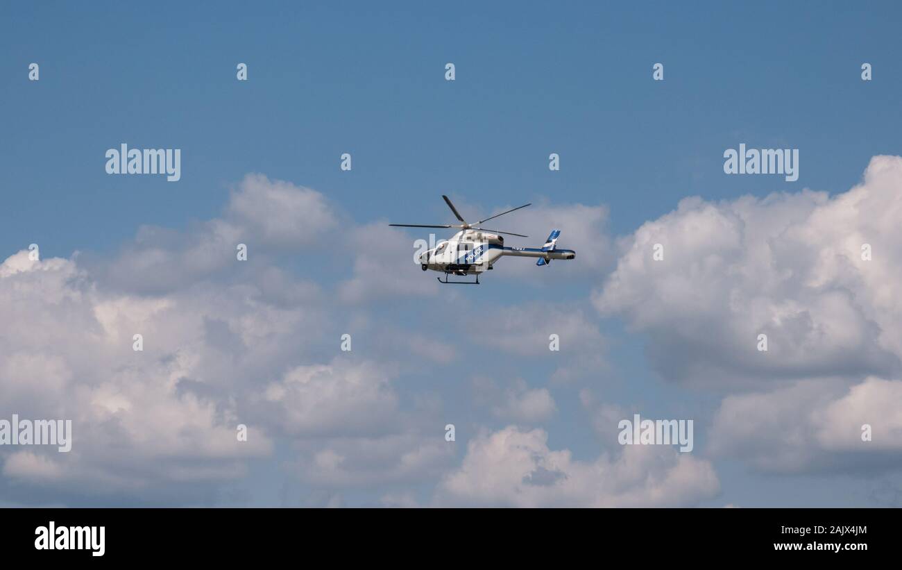 Blau-weißer Polizeihubschrauber, der in den Himmel fliegt Stockfoto