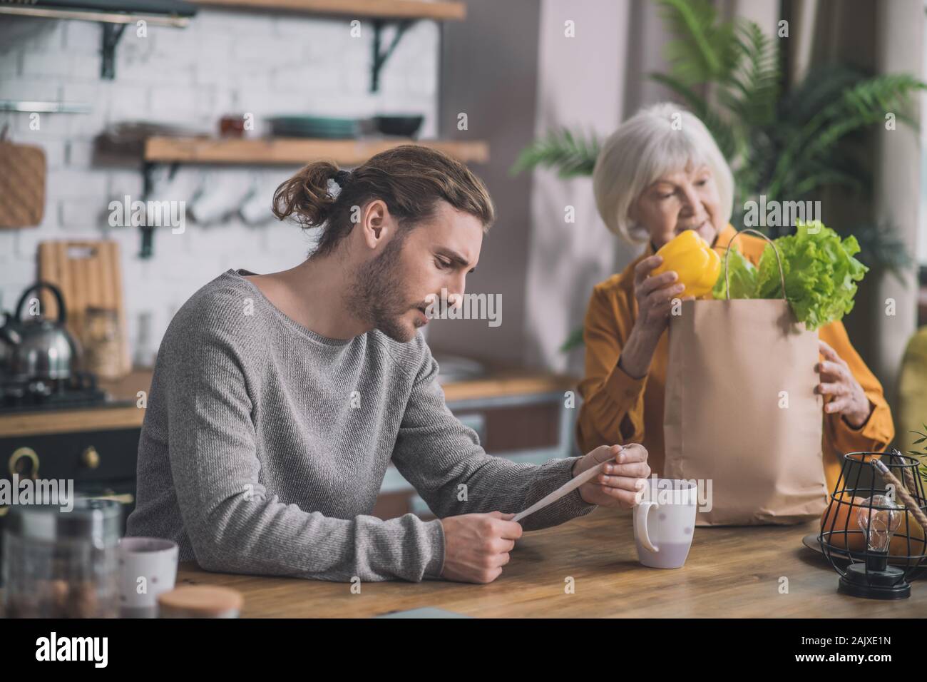 Grauhaarige Mama und ihrem Sohn shopping diskutieren Stockfoto