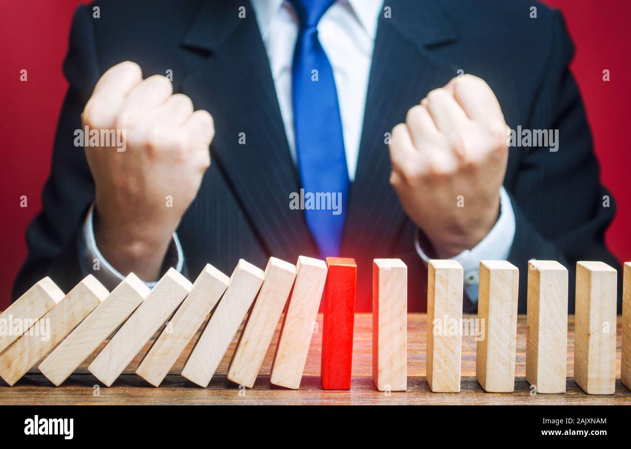 Geschäftsmann ist froh, dass rote Domino der Fall Prozess gestoppt. Einen Weg finden, um das Problem zu halten und seine Ausbreitung zu verhindern. Erfolg und Abschluss Stockfoto