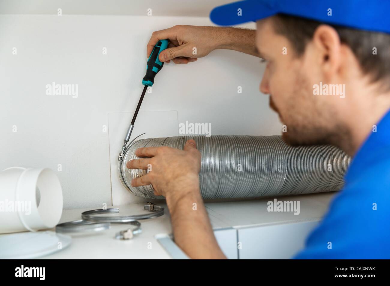 Arbeitnehmer Installation flexible Aluminium Entlüftungsrohr für Küche Dunstabzugshaube Auspuffanlage Stockfoto
