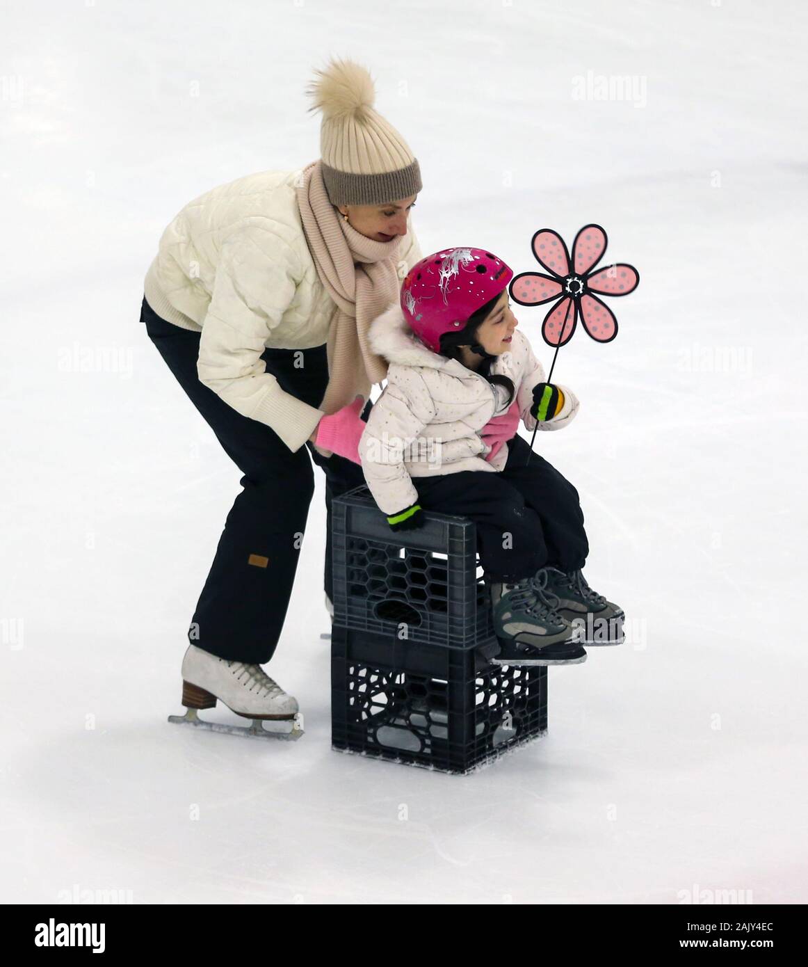 Mutter Eislaufen mit Tochter Stockfoto