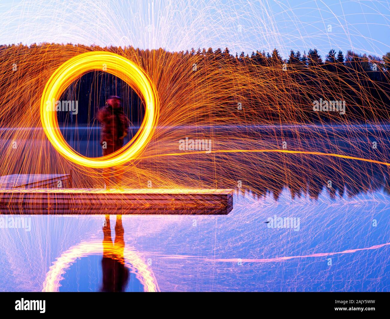 Brennende Stahl Wolle spinnen, Duschen glühende Funken von spinning Stahlwolle, schöne Spiegelungen im Wasser Stockfoto