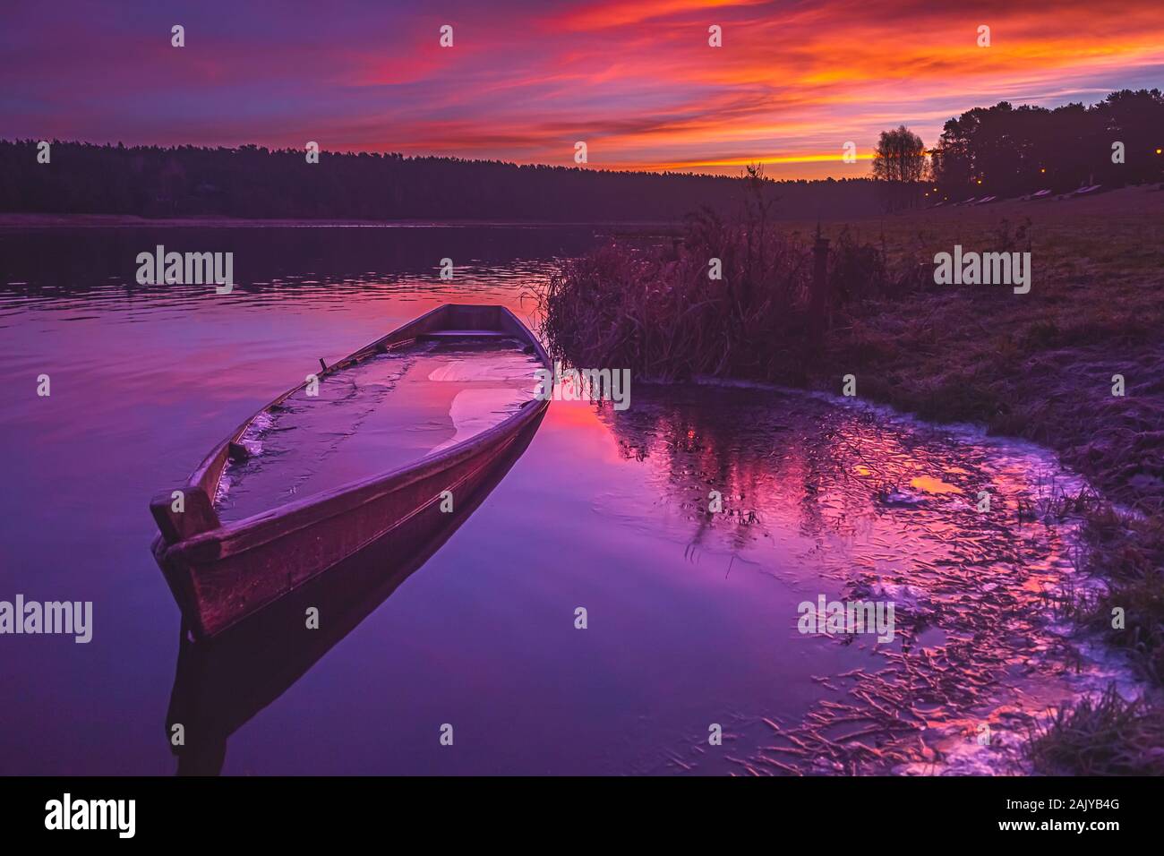 Fischerboot auf einem ruhigen Fluss bei Sonnenaufgang Stockfoto