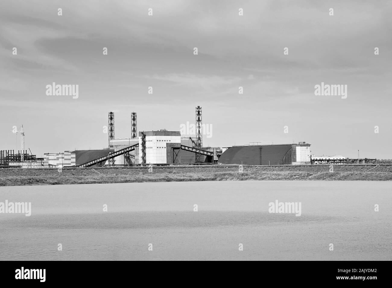 Einen Punkt der Farbe auf der Oberfläche von einem künstlichen Teich auf dem Hintergrund der Fabrik. Stockfoto