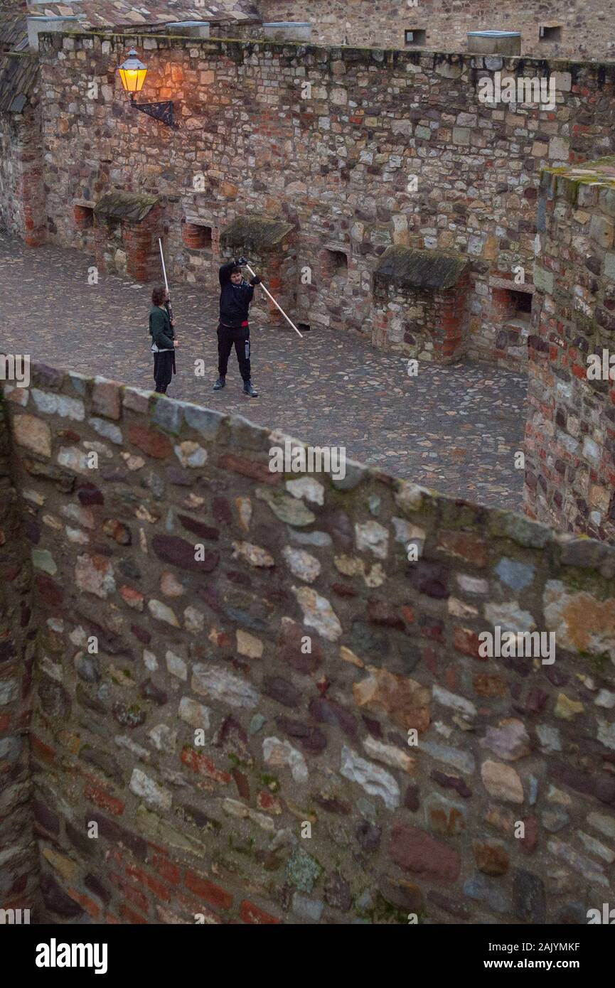 06. Januar 2020, Sachsen-Anhalt, Magdeburg: Tim (l) und Florian aus der Reihenfolge der Johanniter von Magdeburg mit einem Regen und kühlen Temperaturen des Winters Schwertkampf mit einem motante innerhalb der Mauern der Bastion Cleve zu üben. Die Klinge des Spanischen Schwert ist aus Kunststoff und ist stumpf. Die Montante ist mit zwei Händen geführt, ist aber viel leichter als eine klassische Deutsche bi-hander. Der Verein hat es sich zur Aufgabe, die kreuzritter Orden der Johanniter in einem historisch korrekt eingestellt und nimmt regelmäßig an der mittelalterlichen Festival pectaculum Magdeburgense Stockfoto