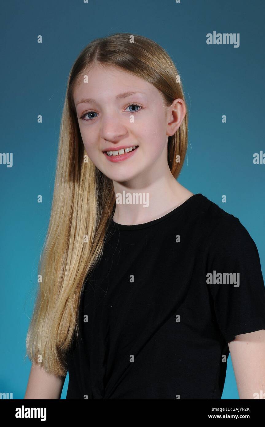 Hübsche blonde Kaukasischen Jugendmädchen in einem schwarzen T-Shirt auf einem hellen abgestuften Hintergrund isoliert Stockfoto