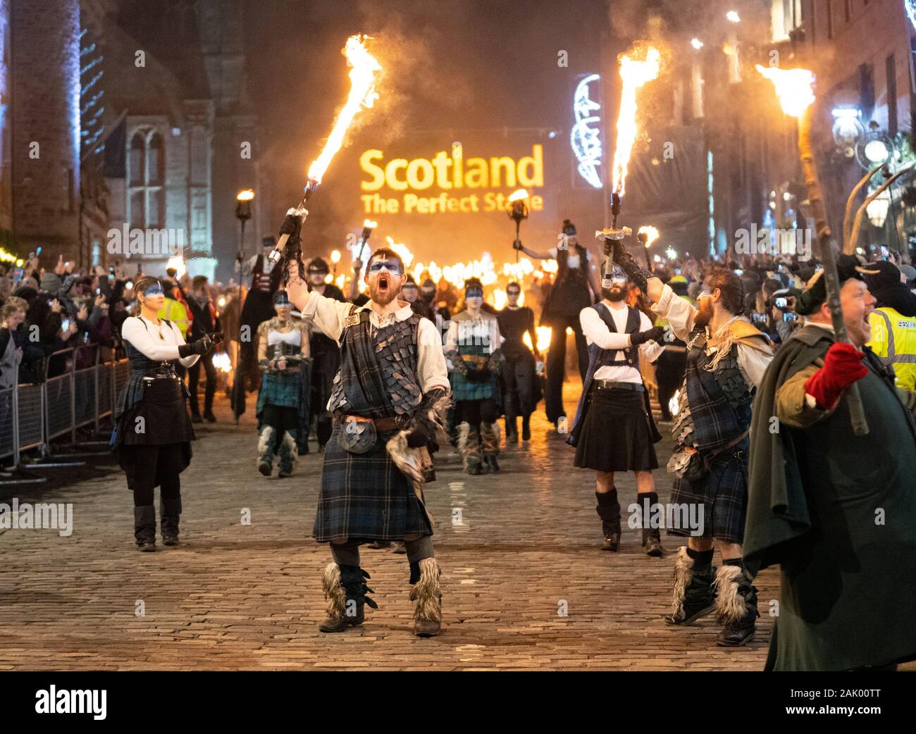 Bei Edinburgh Hogmanay Fackelzug entlang der historischen Royal Mile in der Altstadt und am Ende Holyrood Park, Schottland, Großbritannien Stockfoto