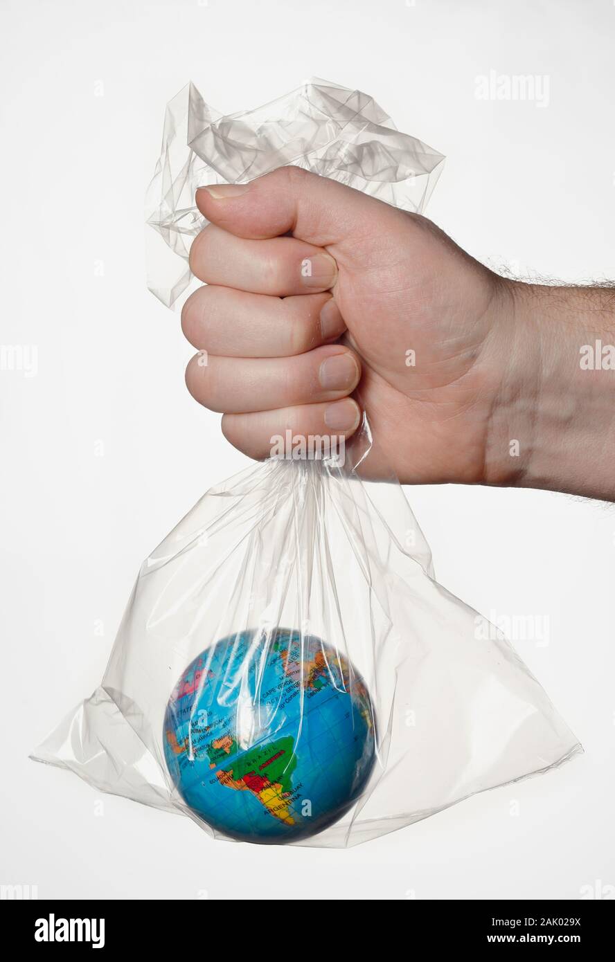 Eine menschliche Hand, die die Erde in einem durchsichtigen Plastikbeutel. Stockfoto