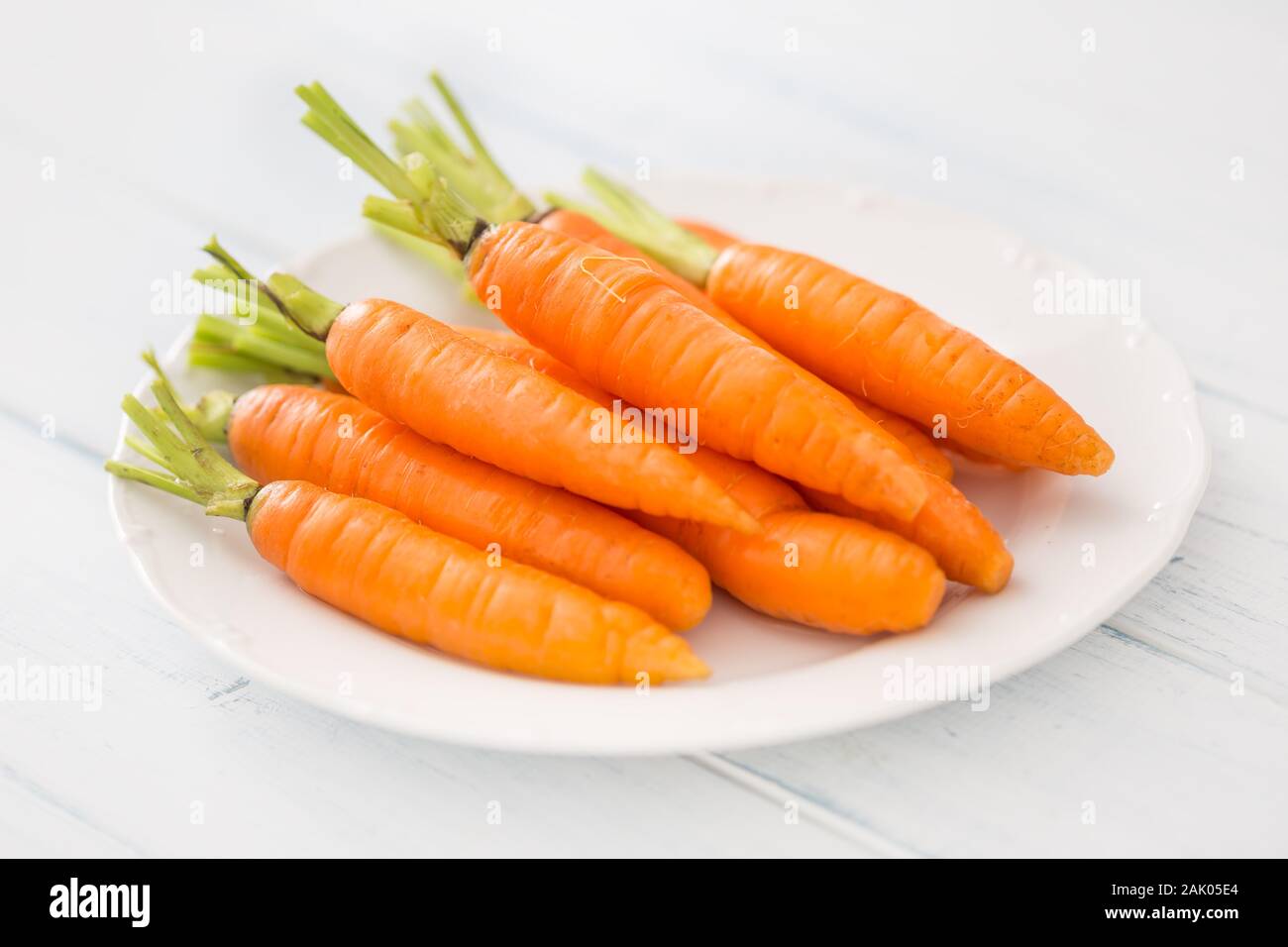 Frische Karotte auf weißen Teller am Tisch Stockfoto
