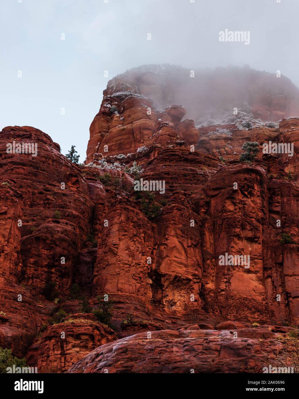 Nebel und Dunst stieg von Sedona, Red Rock Berge und Felsen an einem kalten Wintermorgen mit bewölktem Himmel. Stockfoto
