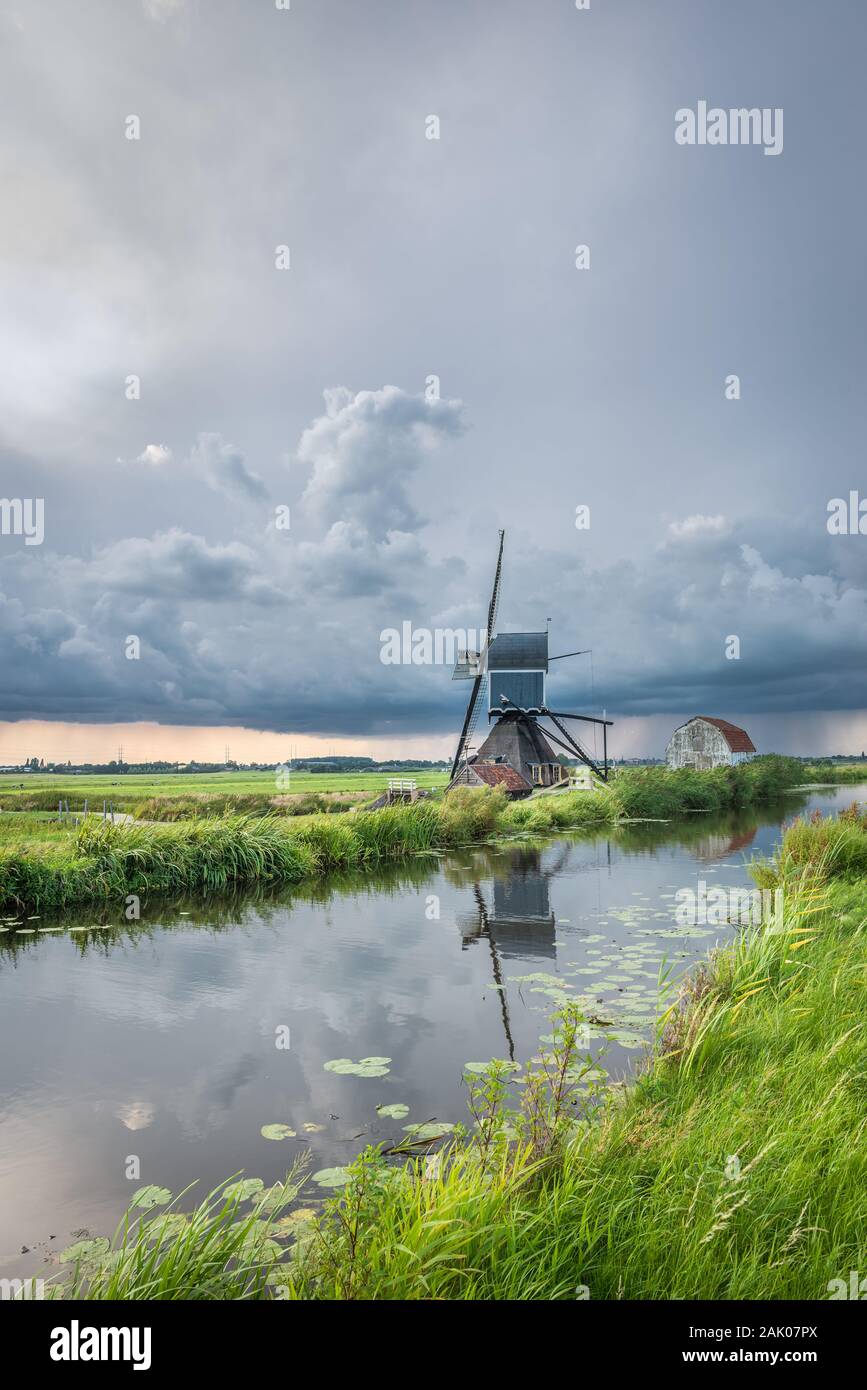 Gewitter über eine klassische holländische Landschaft mit Canal und Windmühle Stockfoto