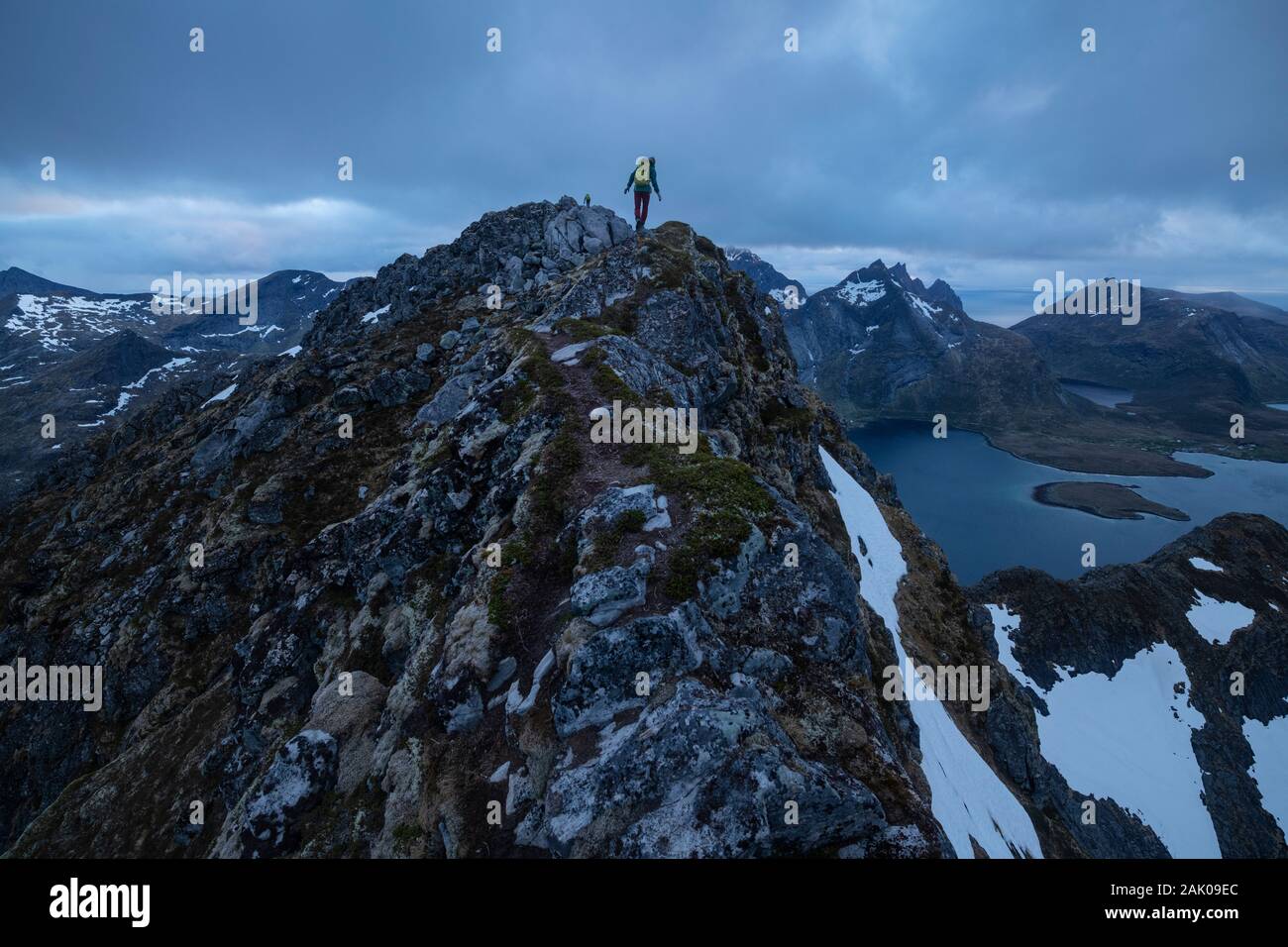 Weibliche Wanderer auf schmaler Gipfelgrat des Narvtind Bergspitze, Moskenesøy, Lofoten, Norwegen Stockfoto