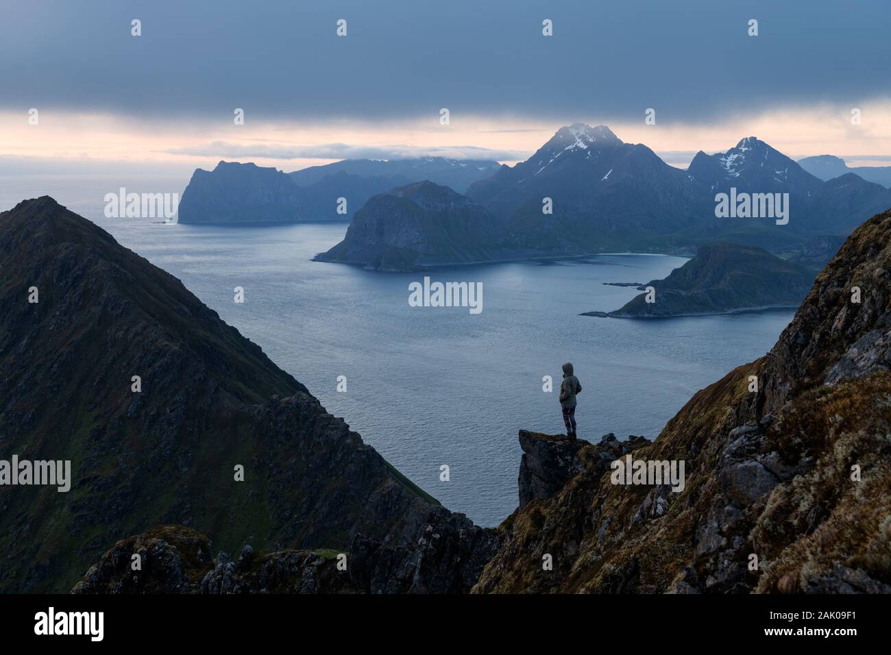 Weibliche Wanderer mit Blick auf Gebirge Landschaft aus Middagstind, Flakstadøy, Lofoten, Norwegen Stockfoto