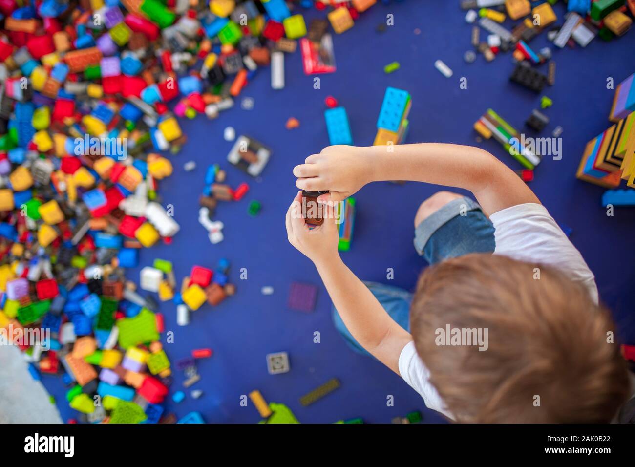 4 Jahre junge Gebäude einen Turm mit mit Verriegelung aus Kunststoff Ziegel Spiel. Selektiver Fokus Stockfoto