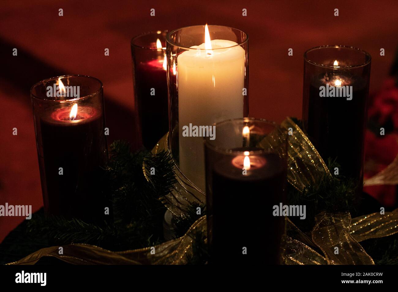 Lila adventskerzen und den weißen Christus Kerze in der Mitte brennen in einer Kirche am Heiligabend. Stockfoto