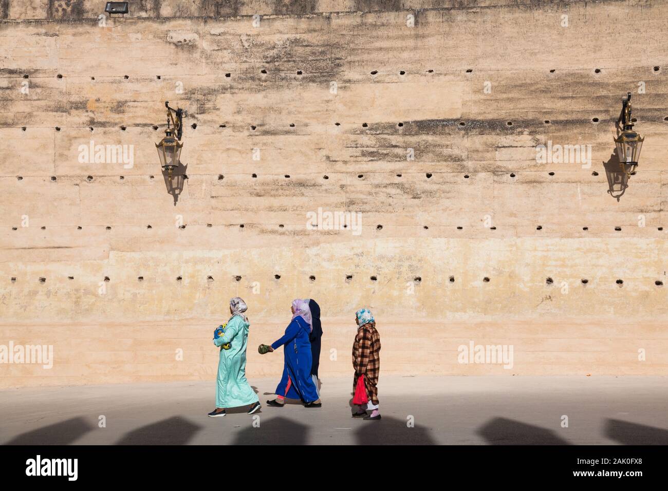 Nur wenige Frauen in farbenfroher Kleidung, die in der Nähe der Stadtmauern im Gebiet von Bab Mechouar und Bab Dekkakin in Fes (Fez), Marokko, spazieren gehen Stockfoto
