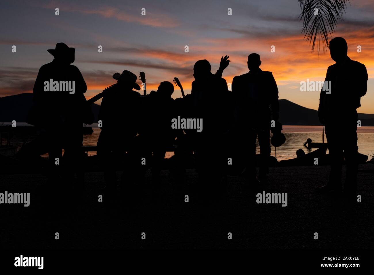 Gruppe von mexikanischen Musikern Silhouette gegen den Sonnenuntergang über der Chapala See, Mexiko Stockfoto