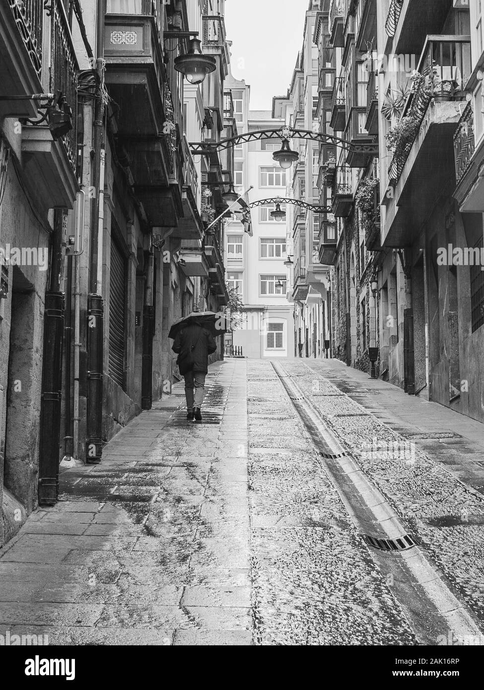Menschen gehen auf die Straße unter dem Regen in Bilbao, Spanien Stockfoto