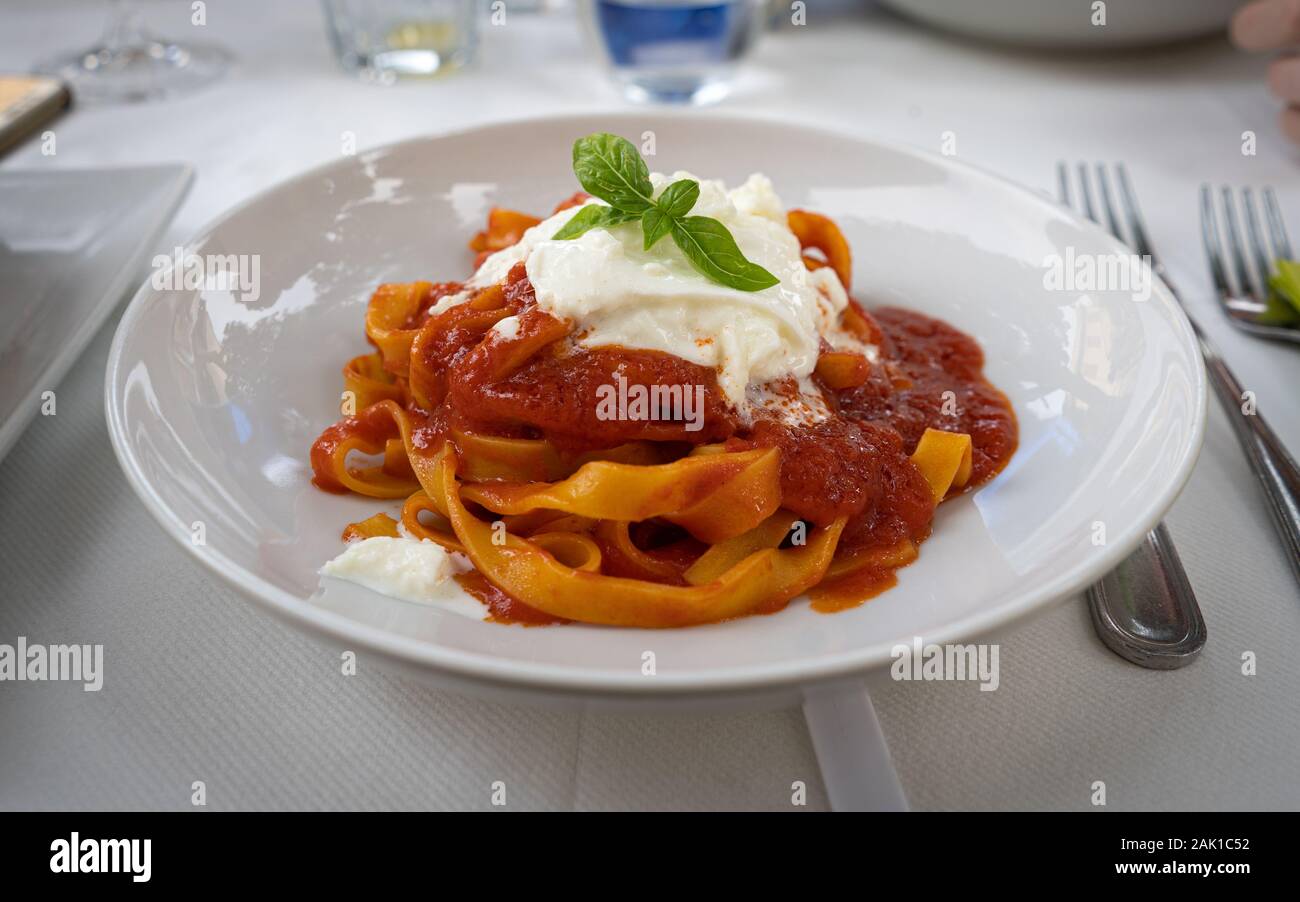 Italienische Pasta mit Tomaten, Mozarella und Basilikum. Nahaufnahme von Pasta im italienischen Restaurant serviert. Stockfoto