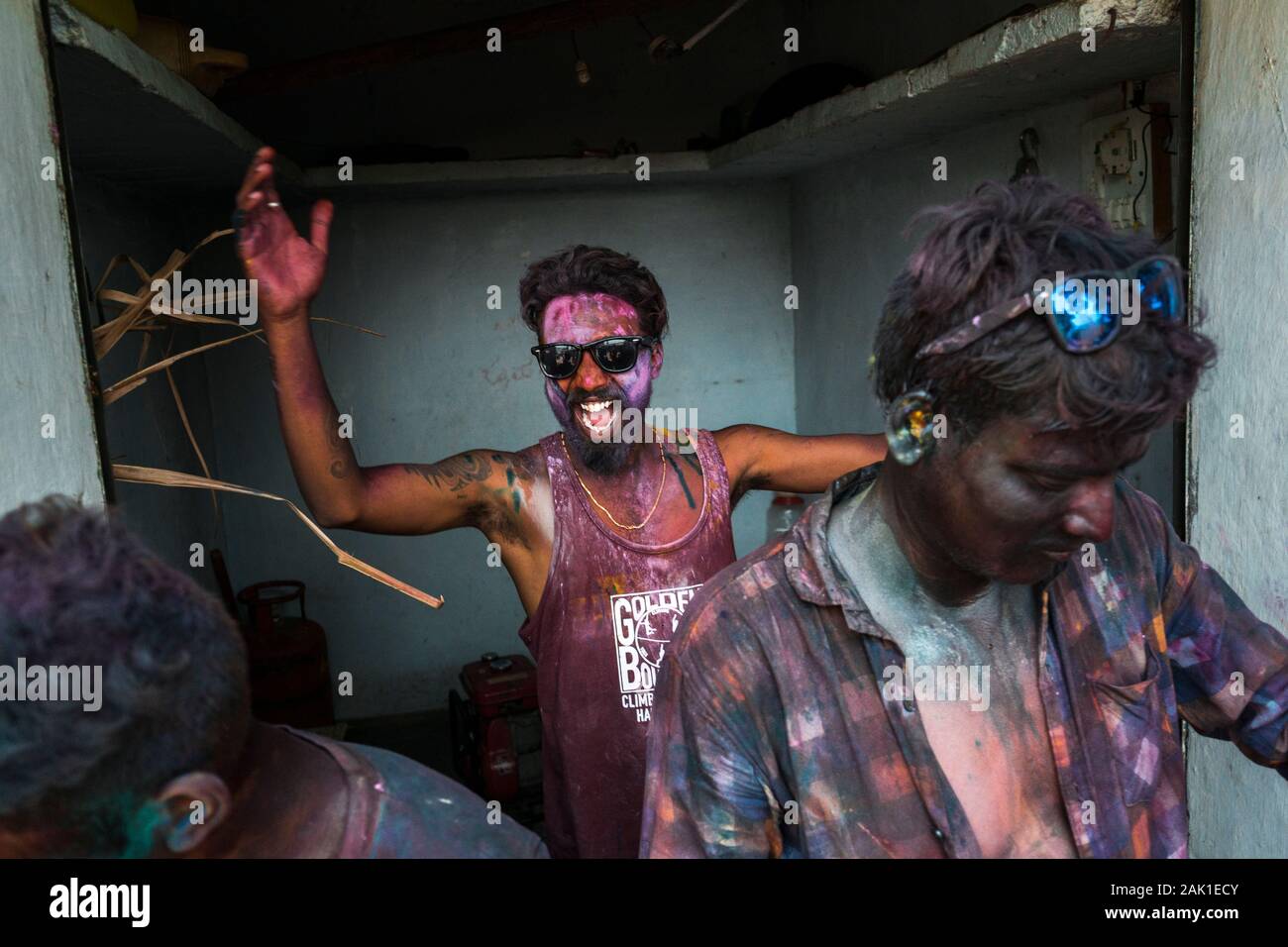 Hampi, Indien - 07. April 2019: Aufgeregter junger indischer DJ, der in bunten Pigmenten bemalte Hände schüttelt, um das Heilige Fest im ländlichen Dorf Hanuman Halli, Karnataka, Indien, zu feiern Stockfoto